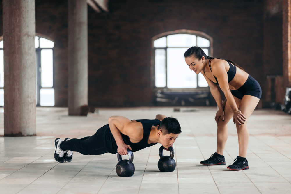 couple doing core workout with kettlebells