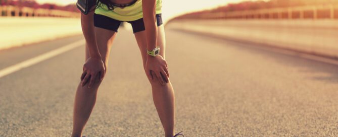 woman taking a break from running outside on the road