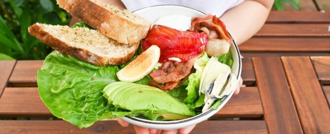 woman holding bowl of balanced macronutrients