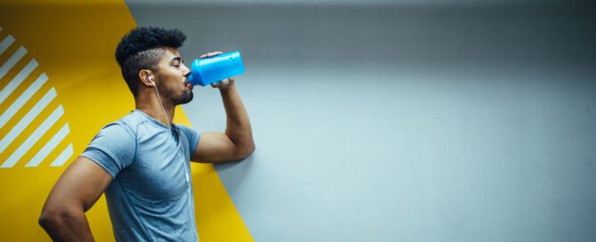 young man drinking a preworkout at the gym