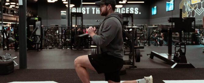 Man performing a back lunge in gym
