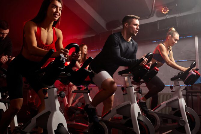 group of athletic people on stationary bikes during a cycling class