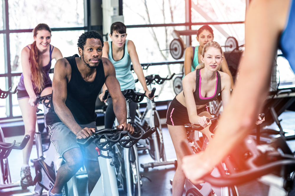 group of people at a spin class at the gym watching the instructor