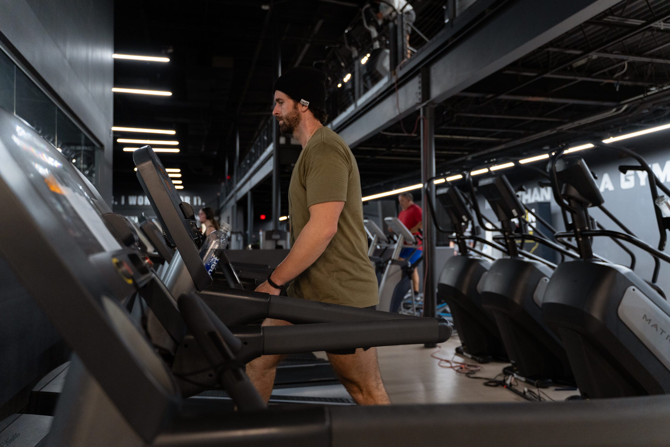 Man walking on treadmill in gym.