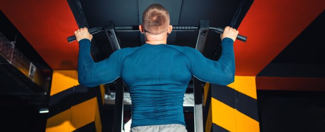Man pull up on bar working back muscles and biceps.