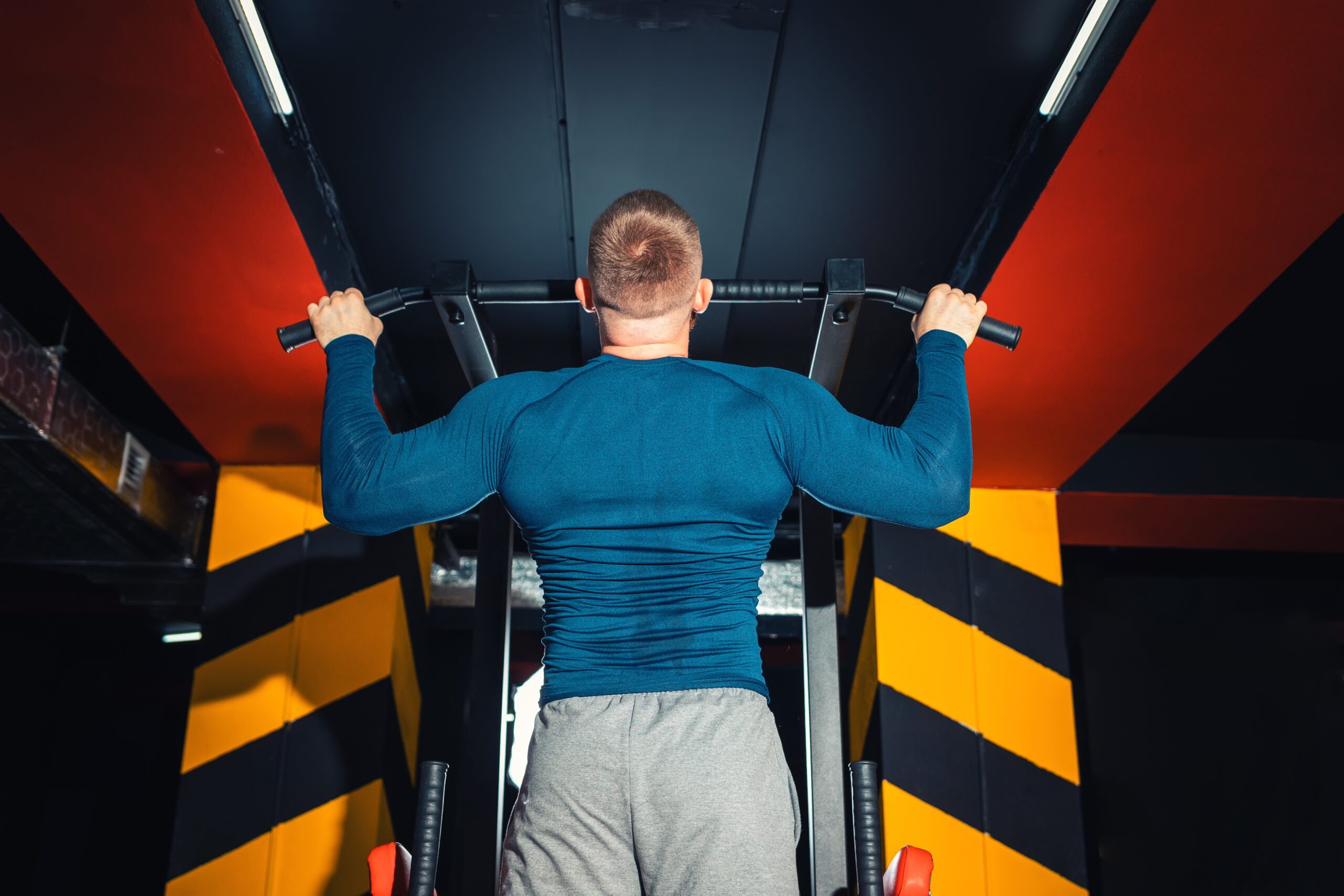 Man pull up on bar working back muscles and biceps.