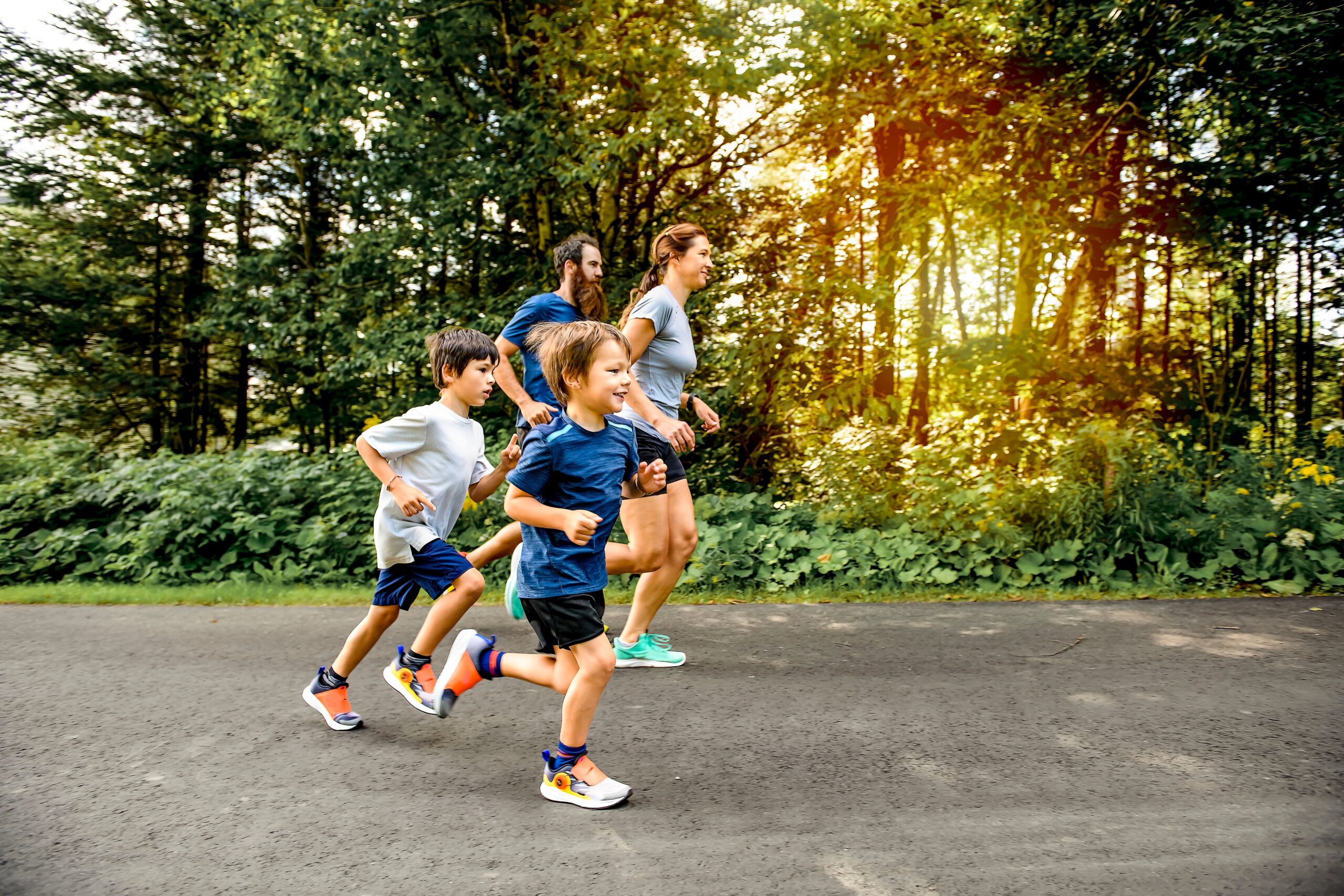 Family jogging together on path outside.