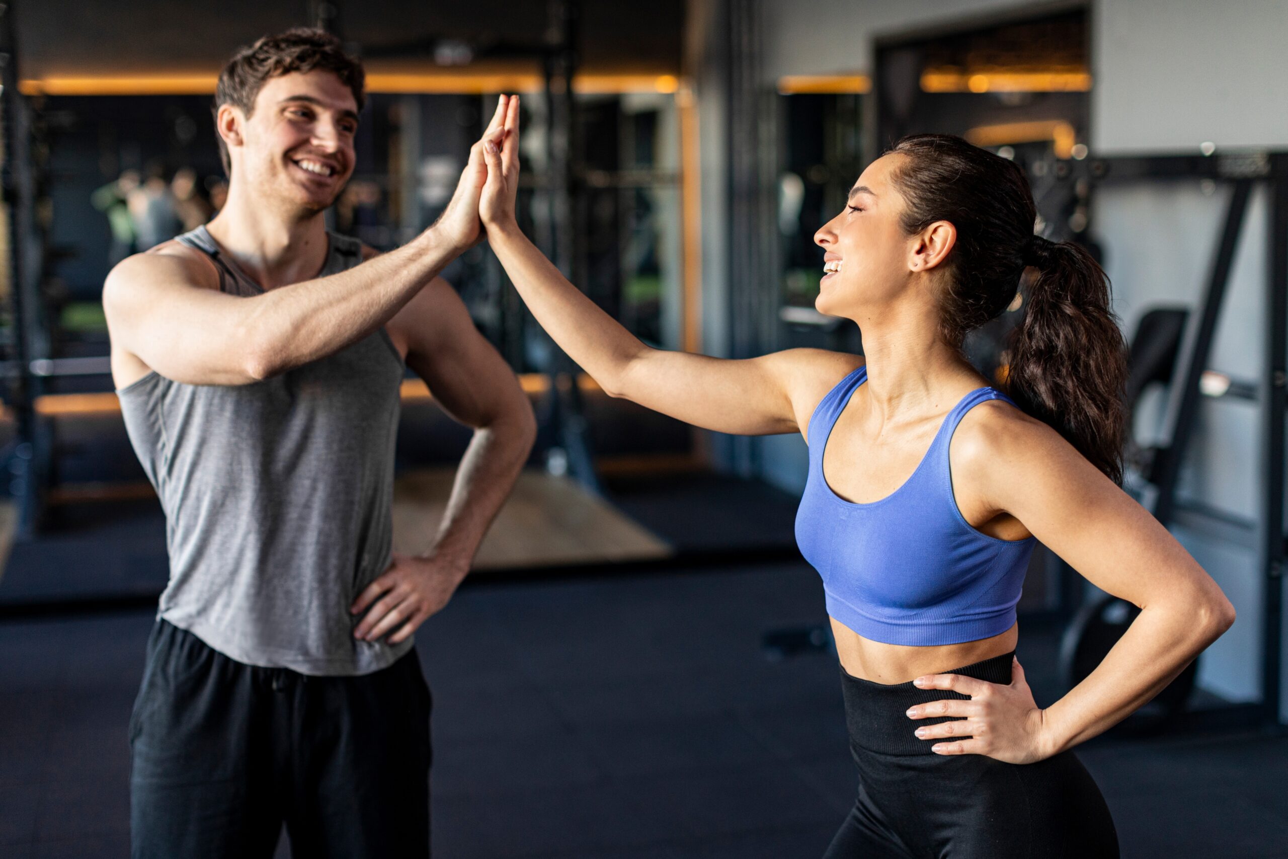 Personal trainer giving client a high five.