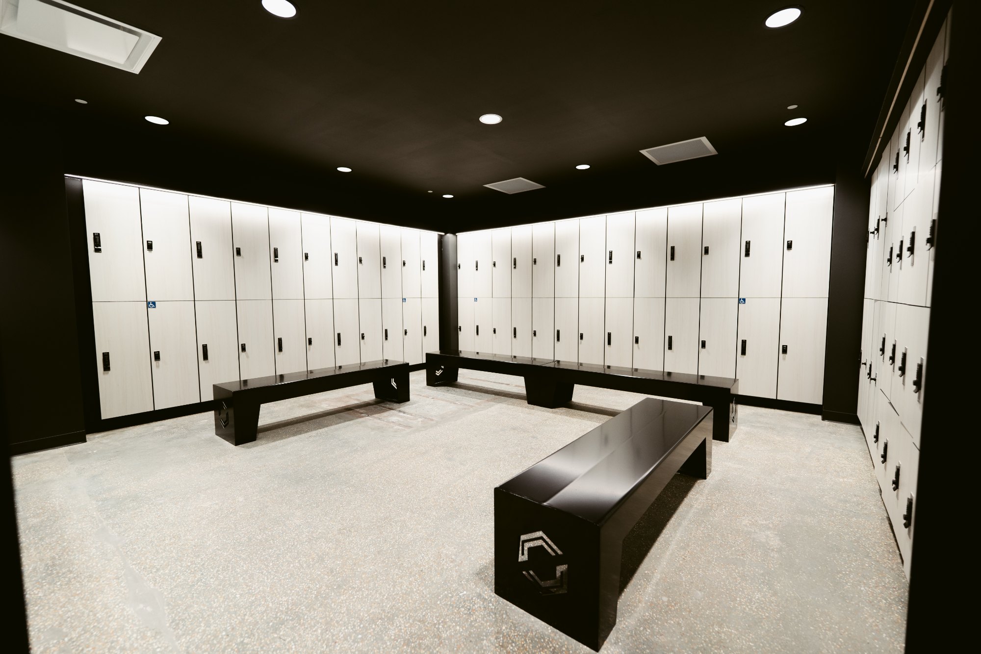 Locker room with light wood lockers and black benches