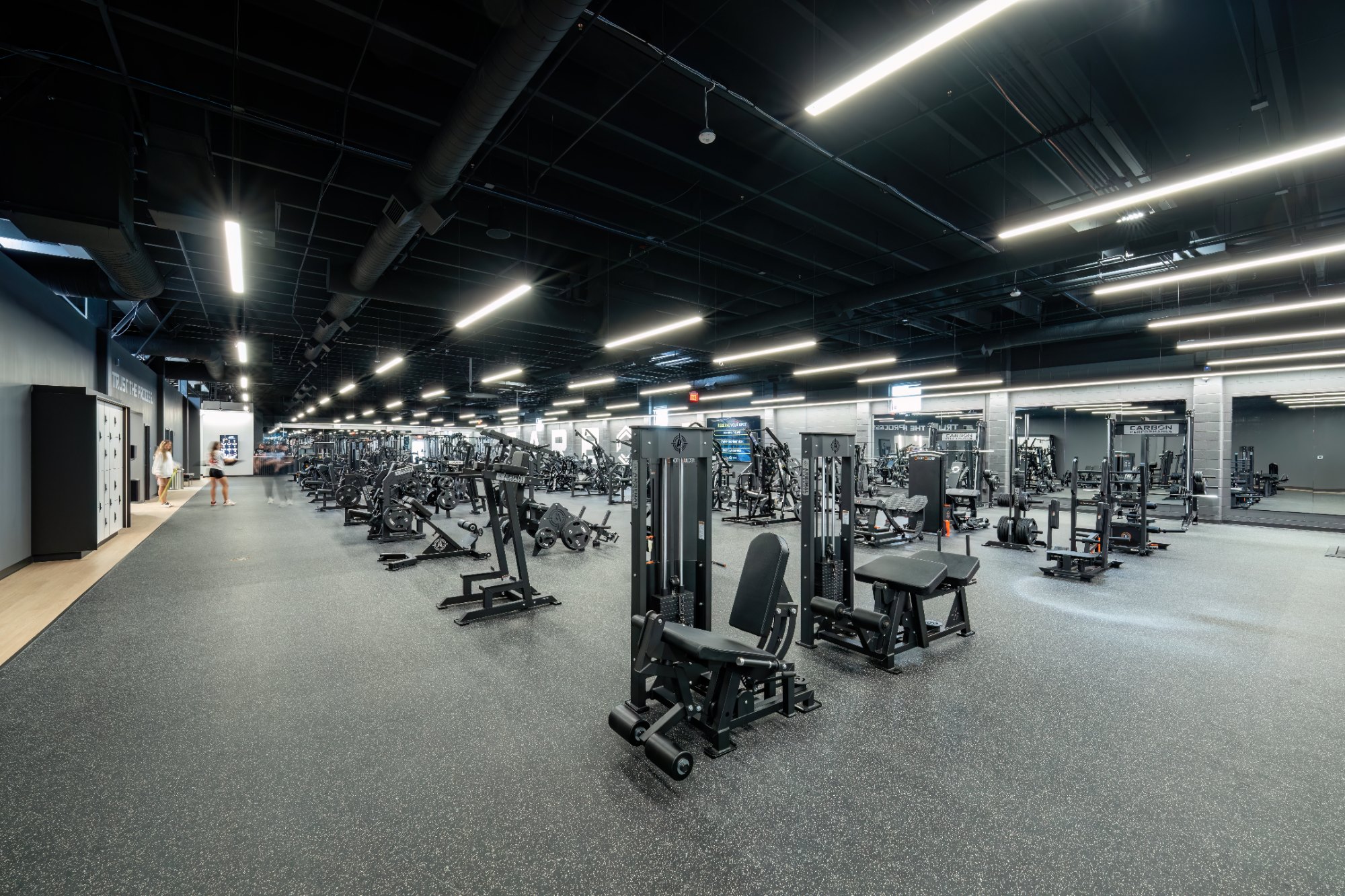 Wide view of the strength floor with plate-loaded machines and Carbon Performance racks